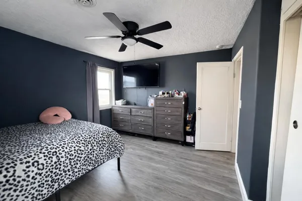 a bedroom with a bed and wooden floor