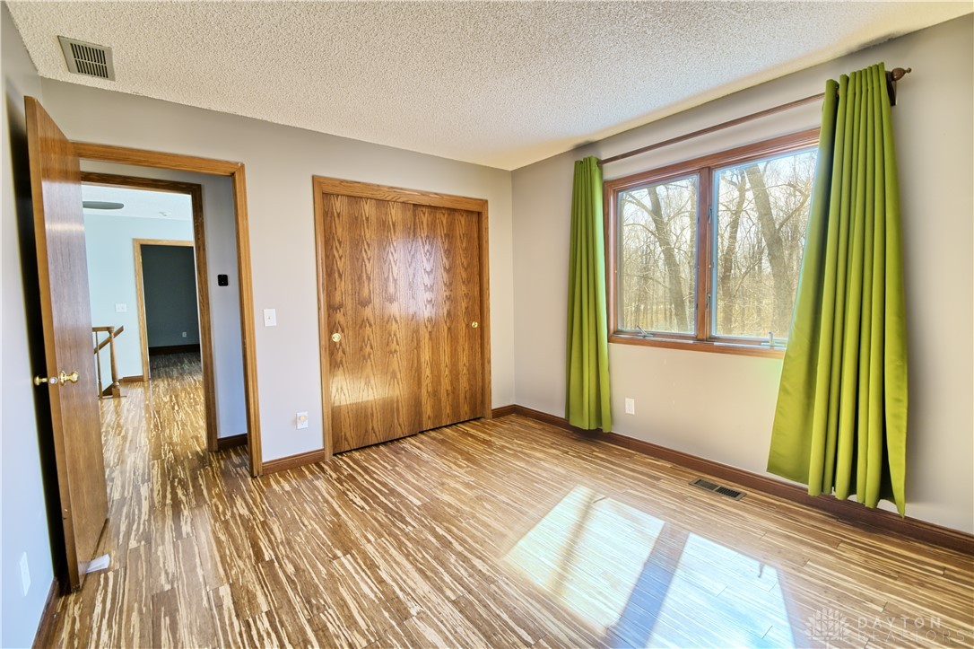 8711 Nicole Lane Springboro, OH 45066 - Photo 56 of 87 This spacious bedroom offers ample natural light and durable wood flooring.