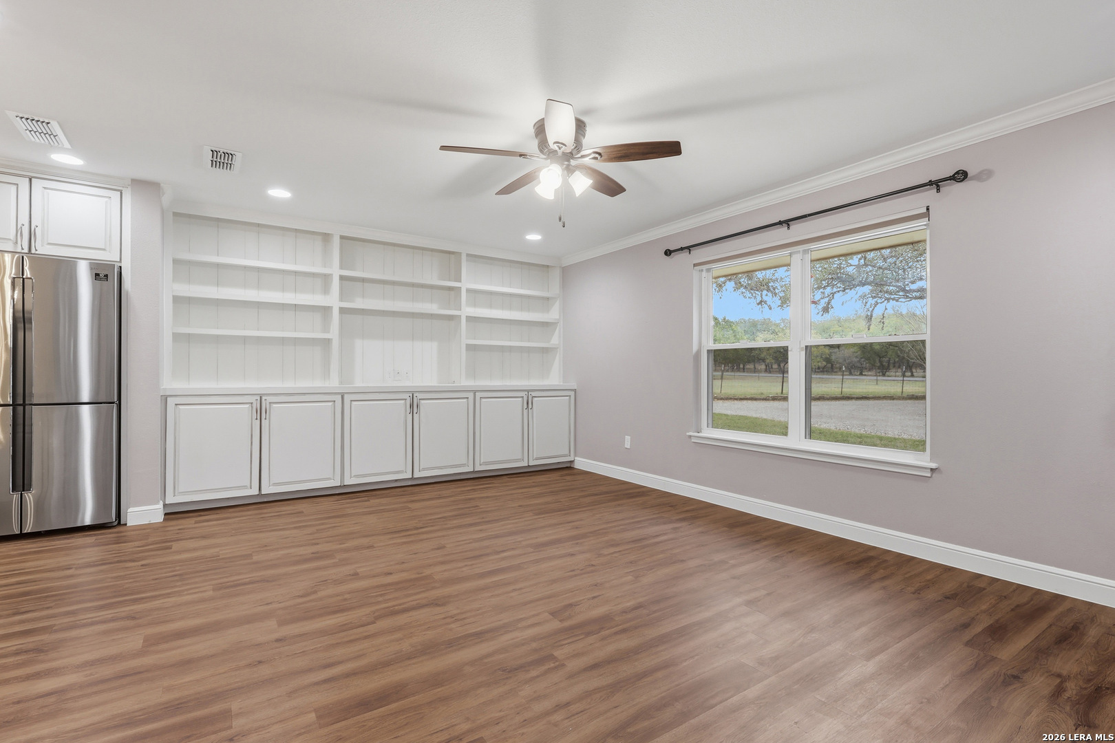 30511 Oakview Road Bulverde, TX 78163 - Photo 3 of 35 a view of an empty room with a window and wooden floor