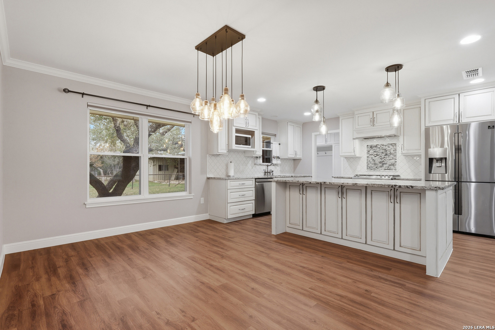 30511 Oakview Road Bulverde, TX 78163 - Photo 6 of 35 a view of a kitchen with wooden floor and stainless steel appliances