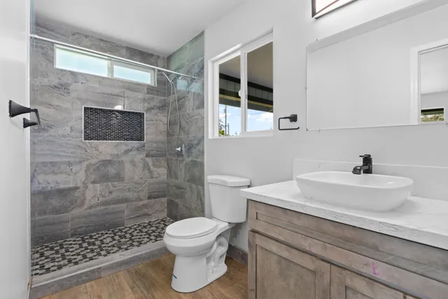 a bathroom with a sink a toilet and shower