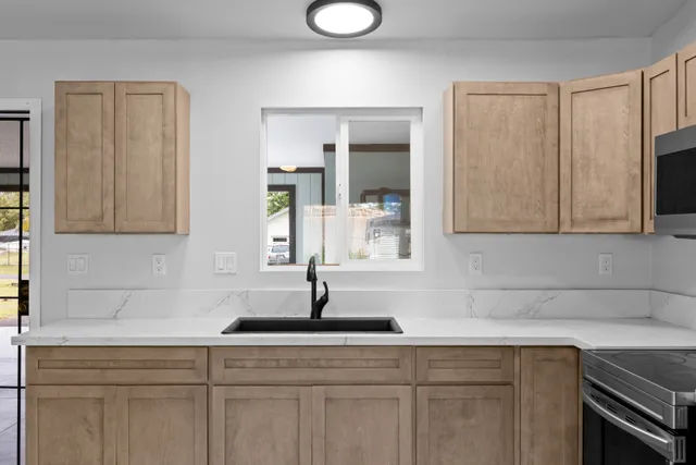 a kitchen with stainless steel appliances granite countertop a sink a microwave cabinets and a granite counter tops