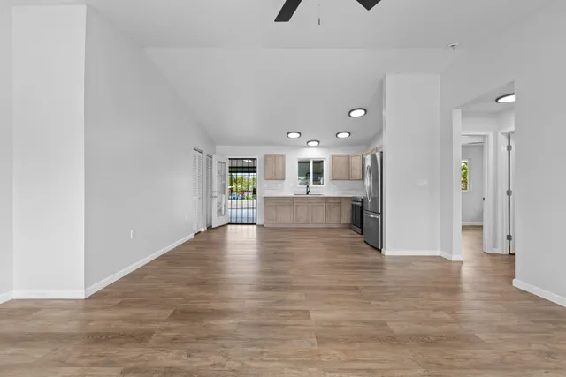 a view of a kitchen with a fridge and wooden floor