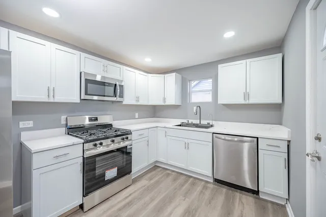 a kitchen with a sink stove top oven and cabinets