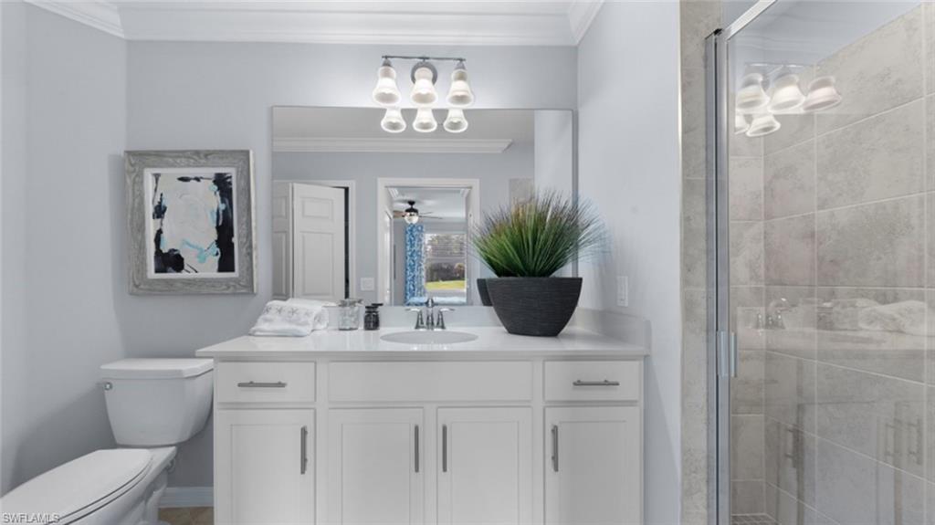 15285 Grn Acrs Avenue, Unit 428 Babcock Ranch, FL 33982 - Photo 7 of 11 Bathroom with a shower stall, vanity, crown molding, and toilet