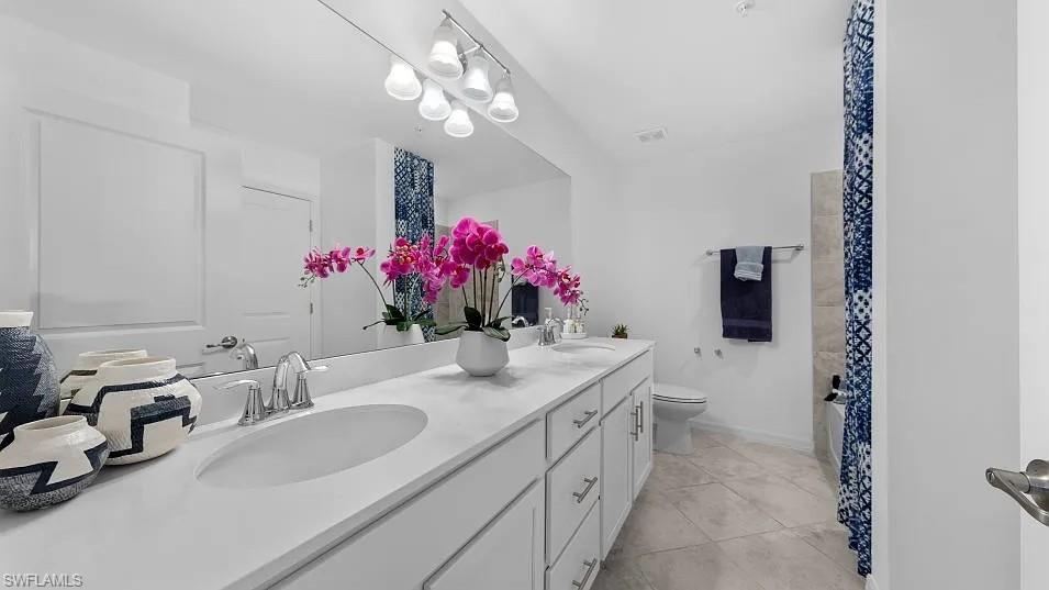 15285 Grn Acrs Avenue, Unit 428 Babcock Ranch, FL 33982 - Photo 9 of 11 Bathroom with a sink, toilet, double vanity, and tile patterned flooring