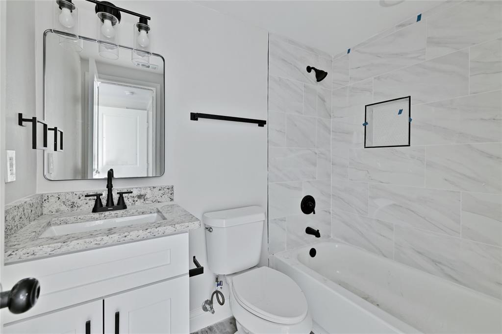 501 North Miller Street Decatur, TX 76234 - Photo 13 of 24 White vanity with black hardware, stone-finish countertop, and undermount sink