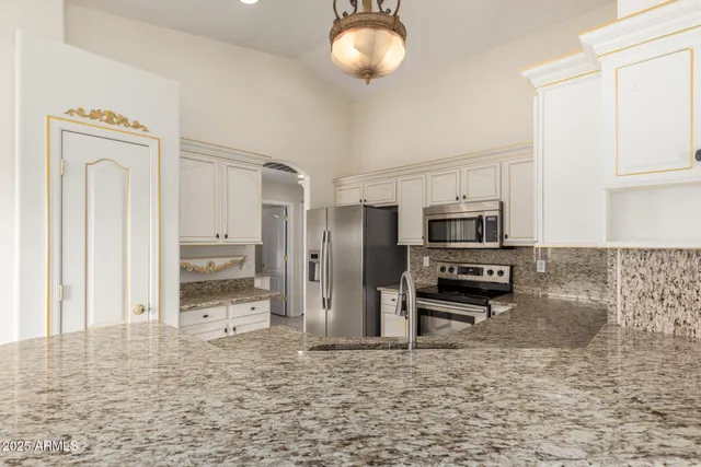 a kitchen with stainless steel appliances a refrigerator a stove top oven and cabinets