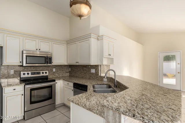 a kitchen with stainless steel appliances granite countertop a sink stove and microwave