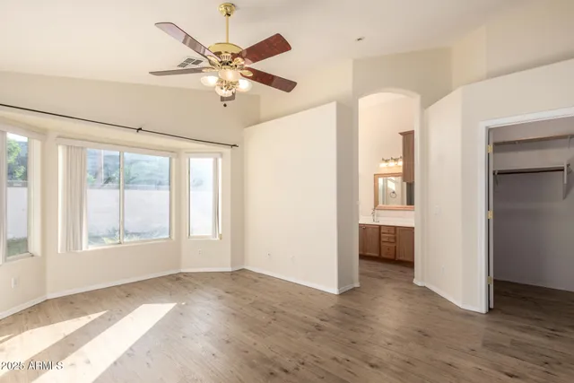a view of an empty room with a window and wooden floor