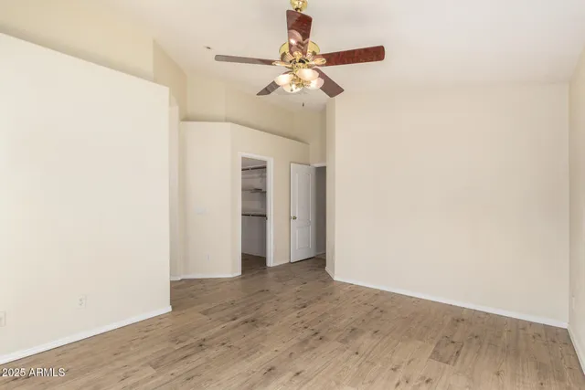 a view of a room with wooden floor and ceiling fan