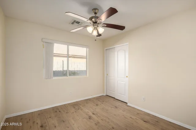 an empty room with a window and a fan