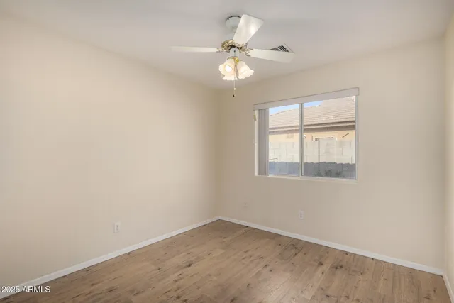 an empty room with a window and a fan