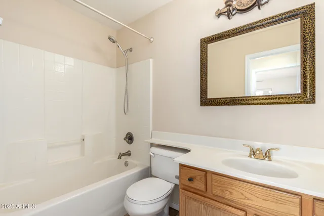 a bathroom with a granite countertop sink a toilet a mirror and shower