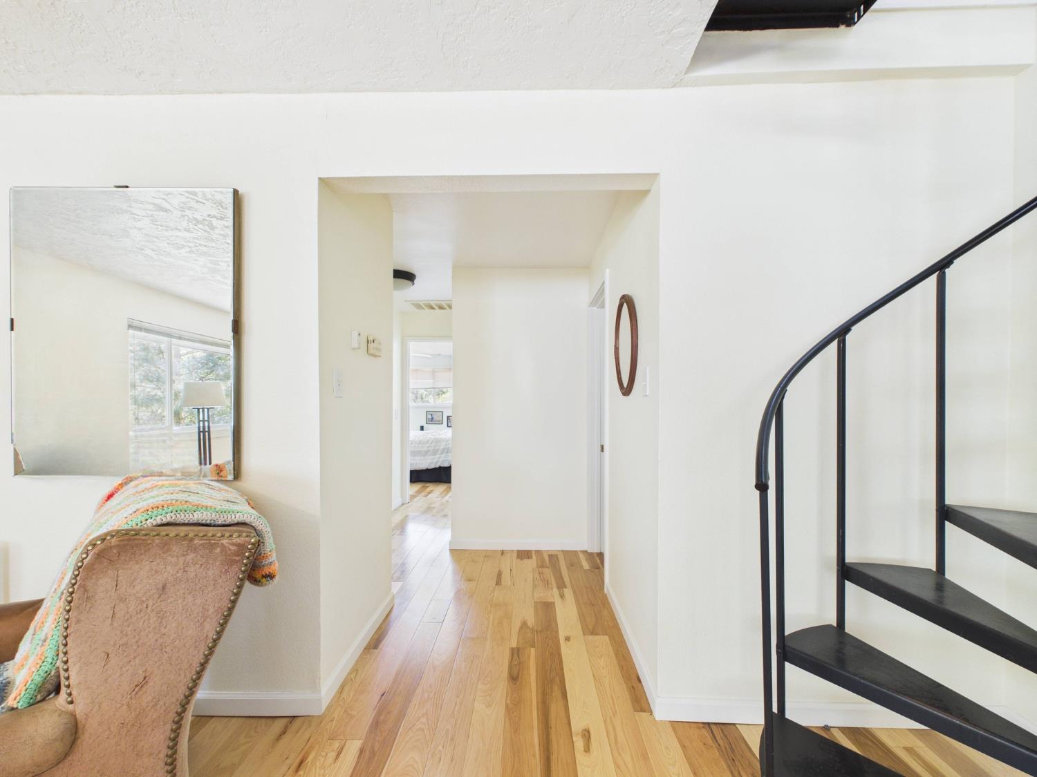 a view of a hallway with wooden floor and staircase