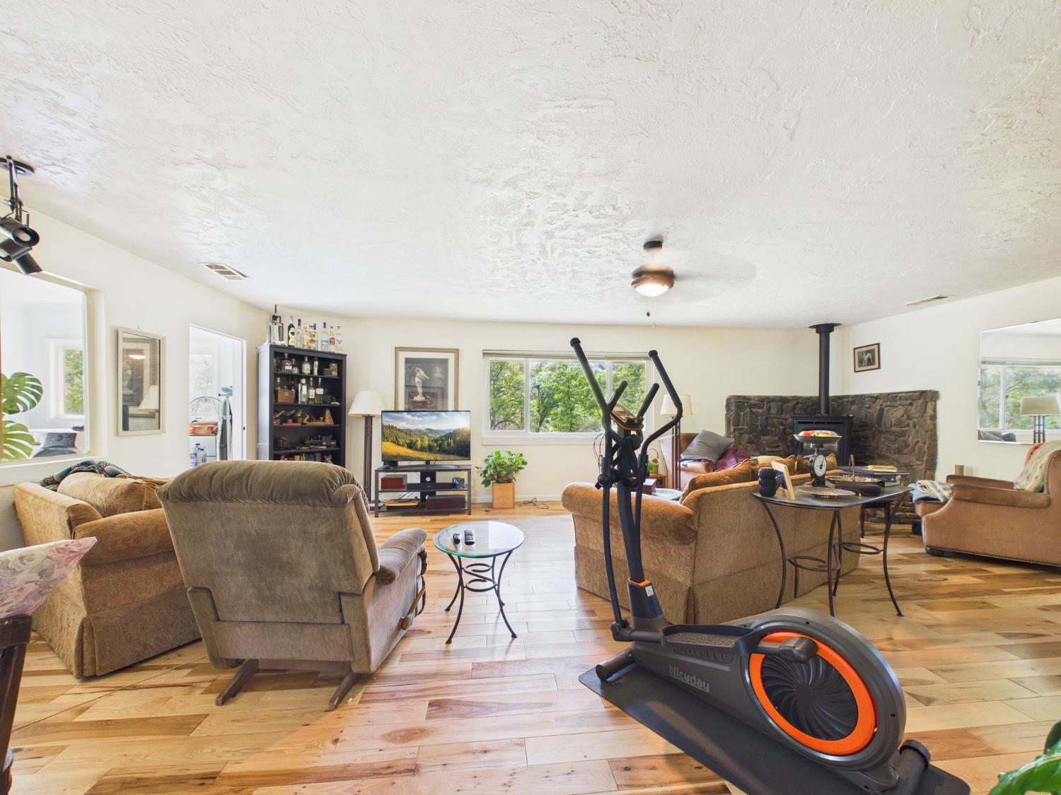 37777 China Creek Road Oakhurst, CA 93644 - Photo 16 of 64 a living room with furniture a window and gym equipment