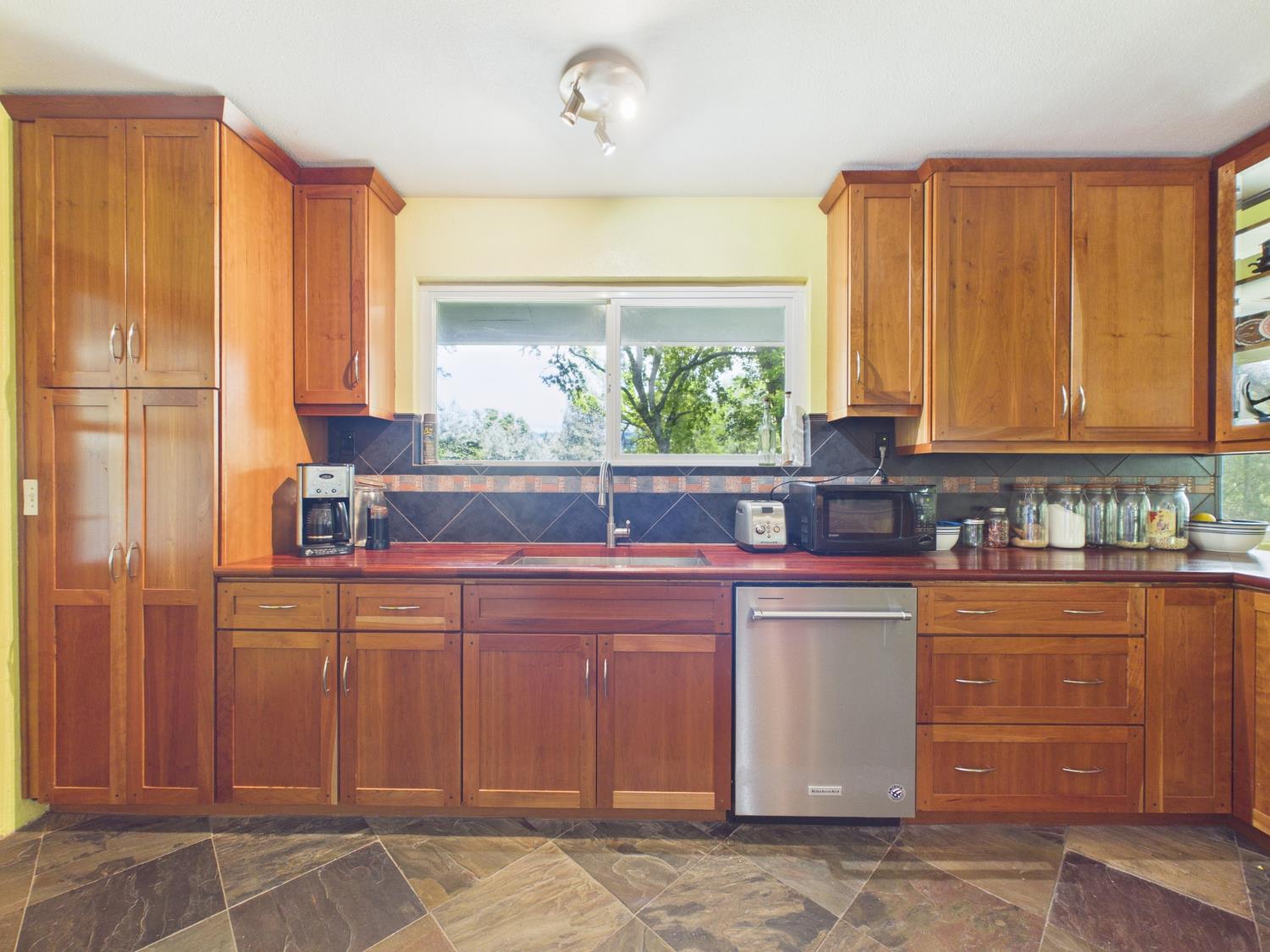 37777 China Creek Road Oakhurst, CA 93644 - Photo 23 of 64 a kitchen with stainless steel appliances granite countertop a refrigerator and cabinets