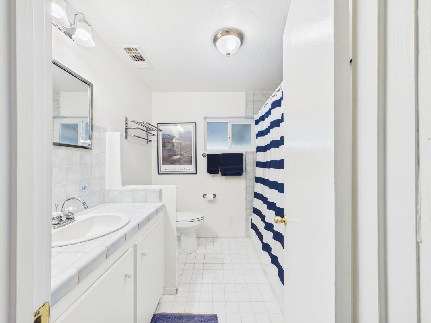 37777 China Creek Road Oakhurst, CA 93644 - Photo 24 of 64 a bathroom with a sink and mirror with shower