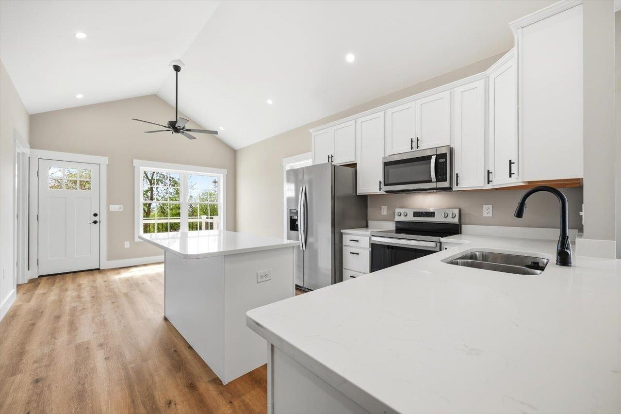 103 Hilltop Terrace Road Staunton, VA 24401 - Photo 7 of 47 a kitchen with stainless steel appliances a stove a sink a refrigerator white cabinets and wooden floor