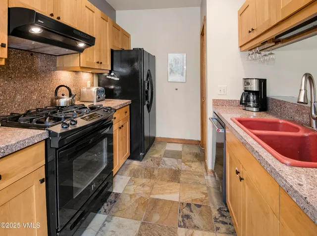 a kitchen with stainless steel appliances granite countertop a stove and a wooden cabinets