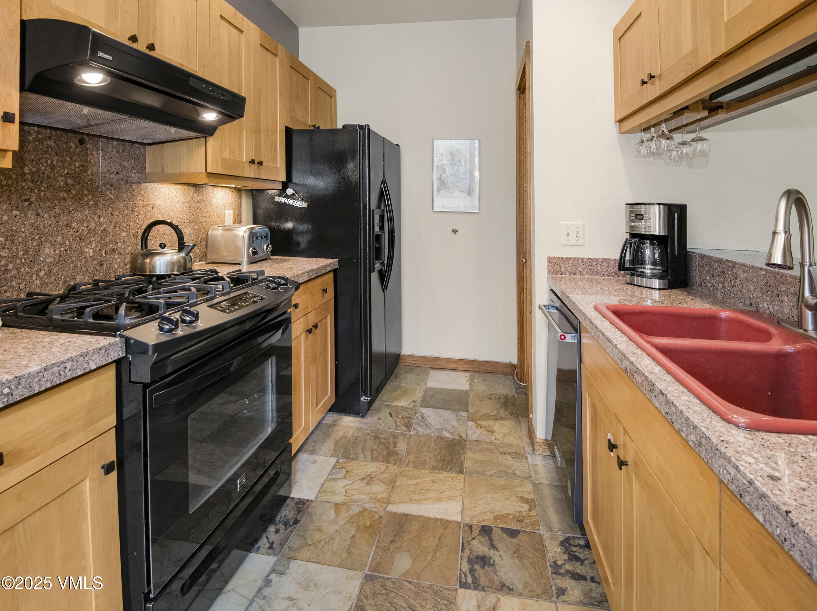 1360 Westhaven Drive, Unit 5A Vail, CO 81657 - Photo 18 of 60 a kitchen with stainless steel appliances granite countertop a sink stove and refrigerator