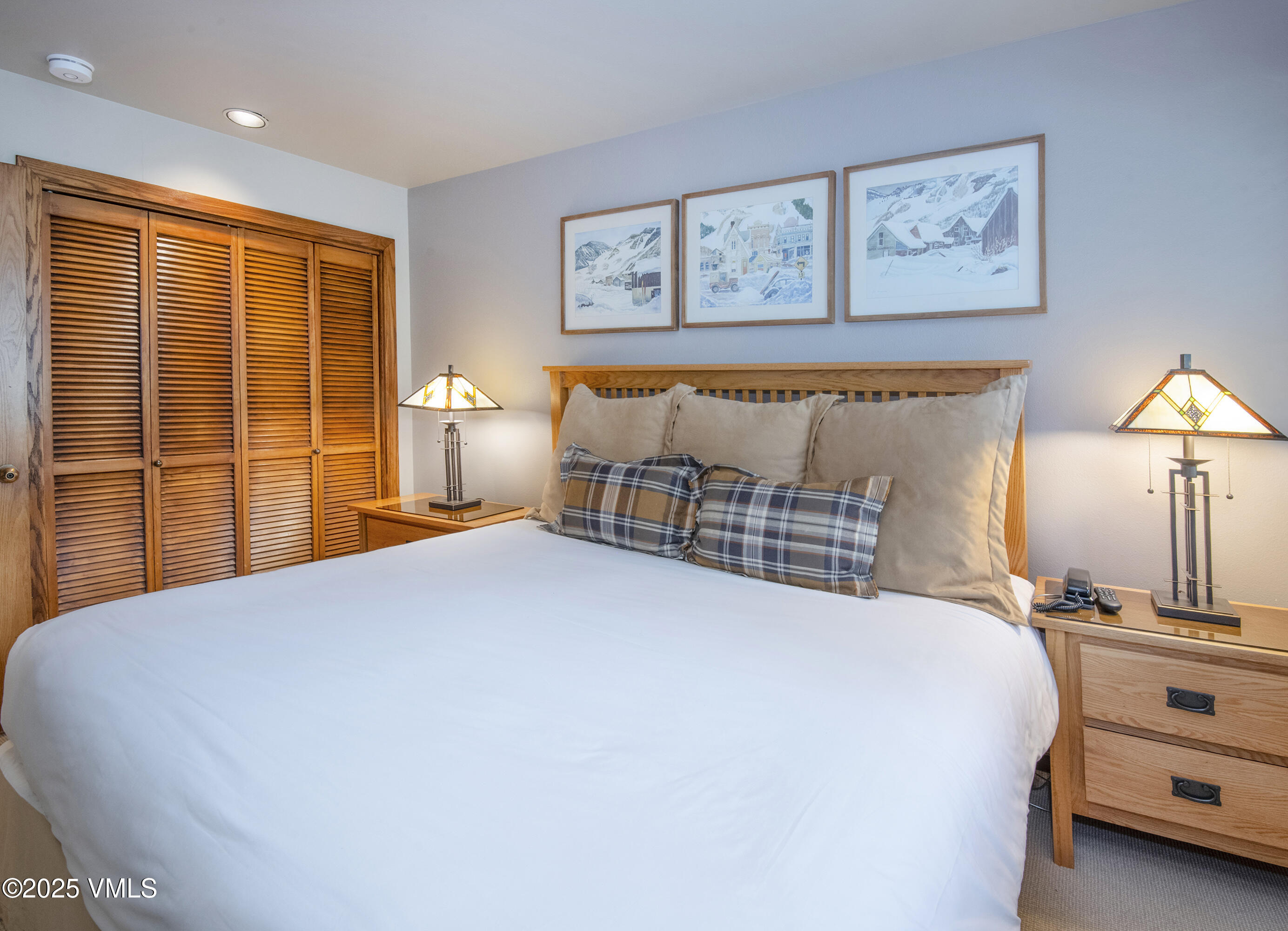 1360 Westhaven Drive, Unit 5A Vail, CO 81657 - Photo 30 of 60 a bedroom with a large bed and a lamp on table