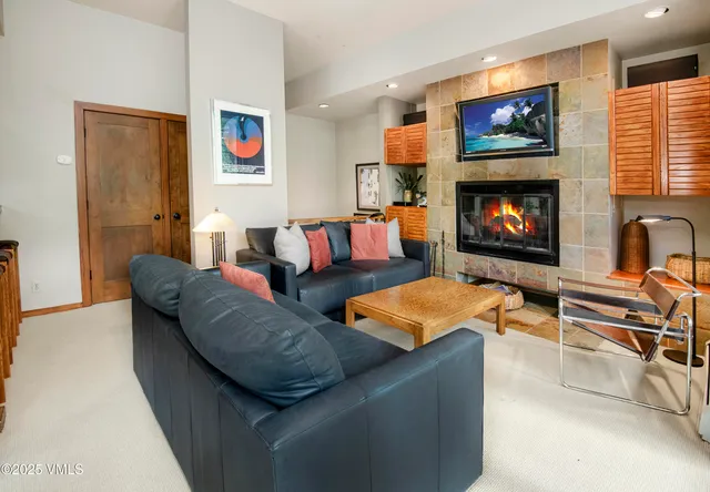 a living room with furniture a flat screen tv and a window