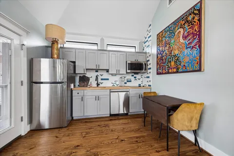 a kitchen with stainless steel appliances granite countertop a refrigerator sink and microwave