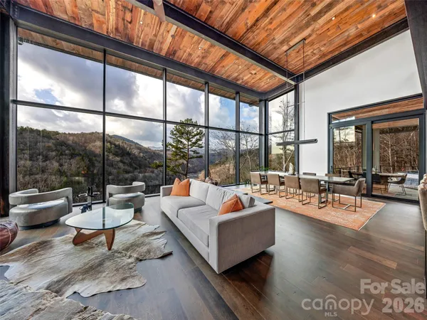 a living room with furniture a table and a large window