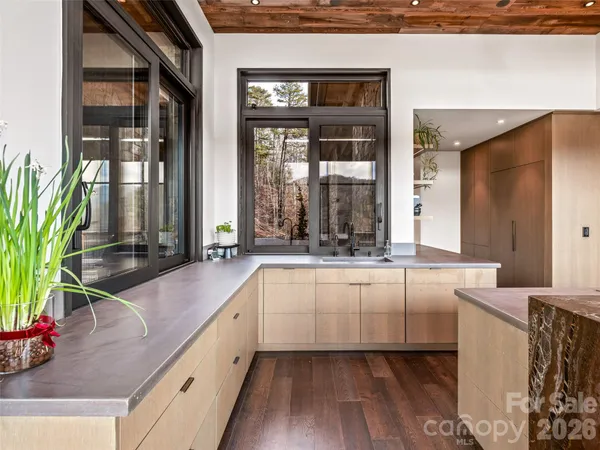 a dining hall with stainless steel appliances granite countertop a refrigerator and a sink