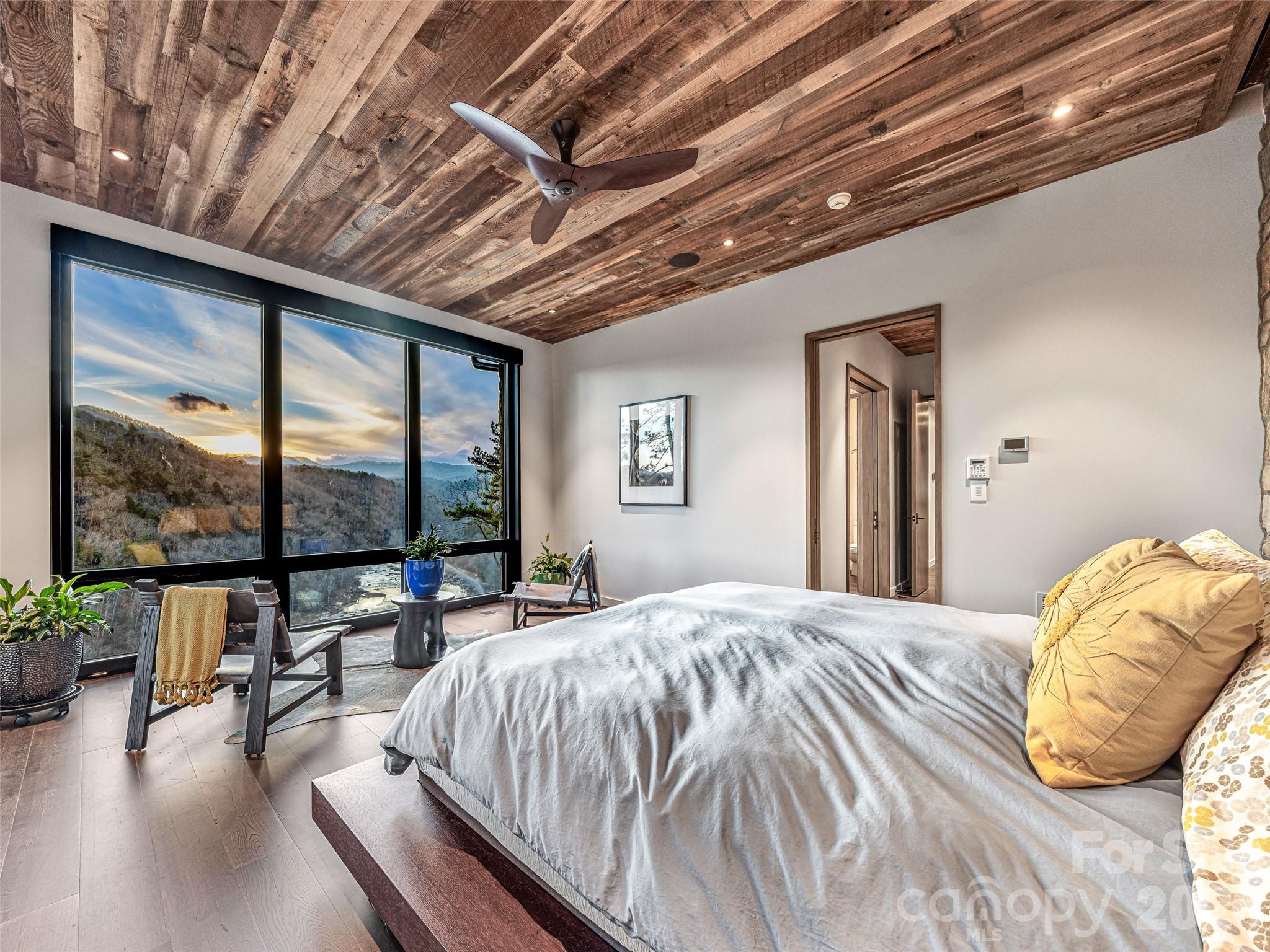 112 Moon Shadow Lane Marshall, NC 28753 - Photo 23 of 48 a bedroom with a large bed a flat tv screen and a balcony view