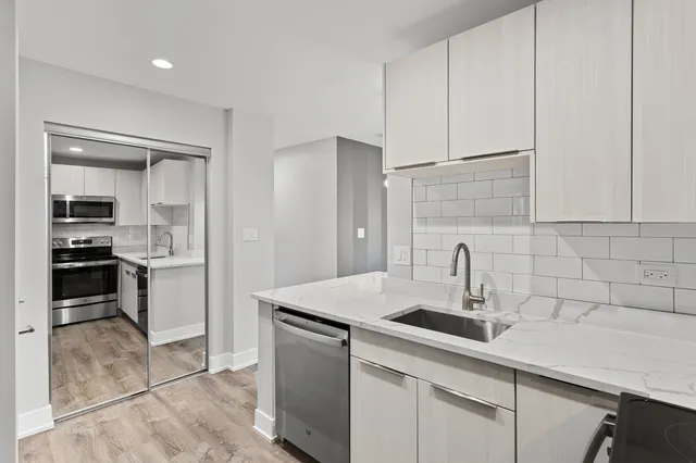 a kitchen with a sink cabinets and stainless steel appliances