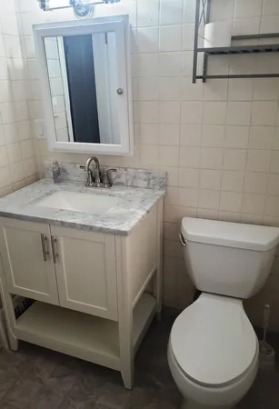 a bathroom with a toilet sink and mirror