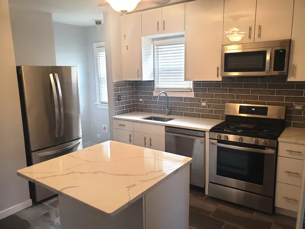 a kitchen with stainless steel appliances kitchen island a stove a sink dishwasher and refrigerator