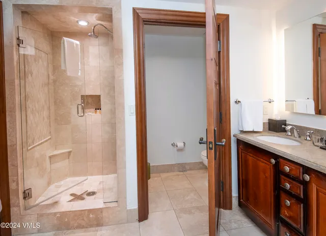 a spacious bathroom with a tub sink and mirror