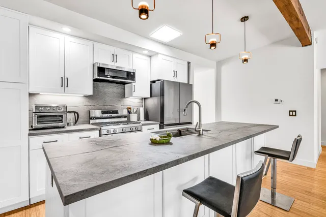 a kitchen with stainless steel appliances granite countertop a sink refrigerator and cabinets