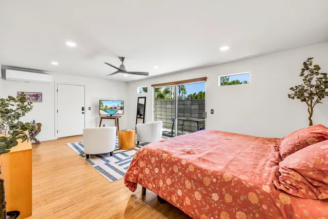 a bedroom with a large bed and wooden floor