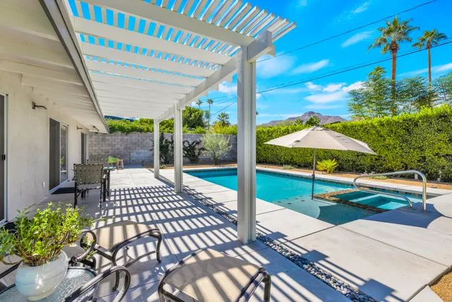 a view of a patio with a table and chairs under an umbrella