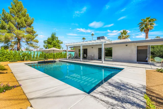 a view of a patio with couches table and chairs and potted plants