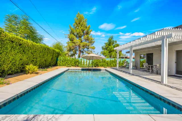 a view of a house with swimming pool and sitting area