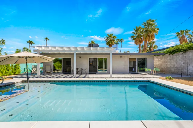 a view of a house with pool and sitting area
