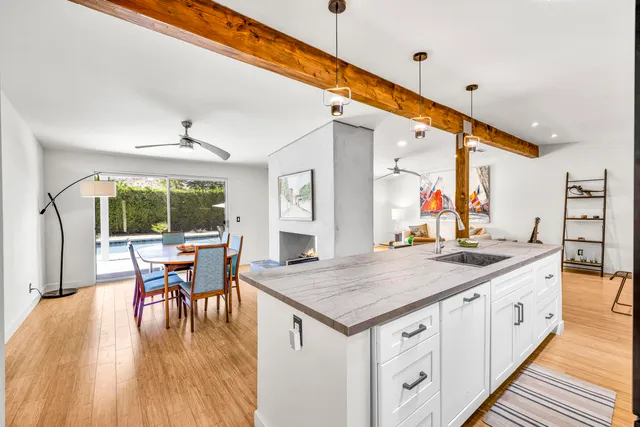 a kitchen with a table chairs and wooden floor