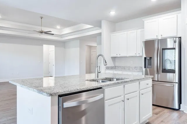 a kitchen with stainless steel appliances granite countertop a sink cabinets and refrigerator