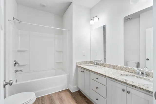 a bathroom with a granite countertop sink toilet tub and shower