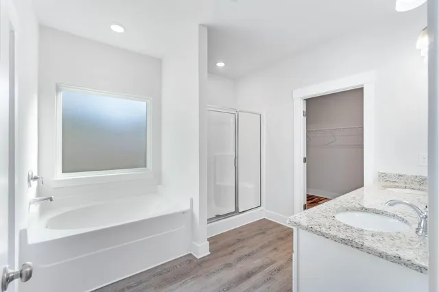 a bathroom with a granite countertop sink and a bathtub