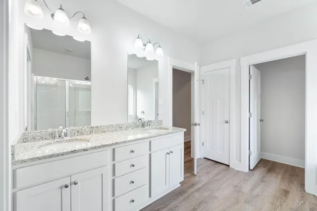 a bathroom with a granite countertop double vanity sink and a mirror
