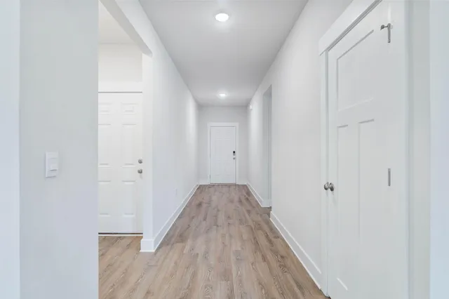 a view of a hallway with wooden floor