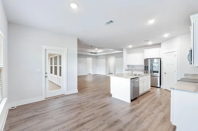 a kitchen with granite countertop a refrigerator and wooden floor