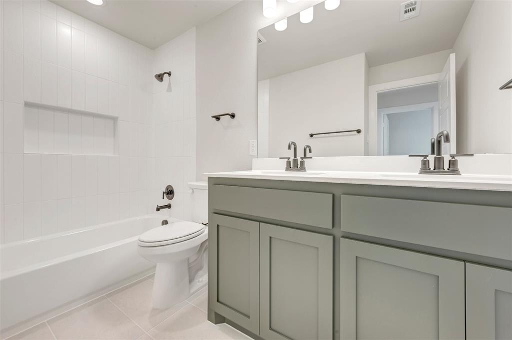 4308 Palomino Road Aubrey, TX 76227 - Photo 38 of 40 a bathroom with a sink toilet a mirror and bathtub