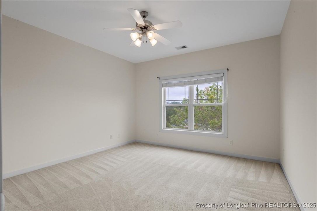 930 Westland Ridge Road Fayetteville, NC 28311 - Photo 44 of 50 an empty room with chandelier fan and windows